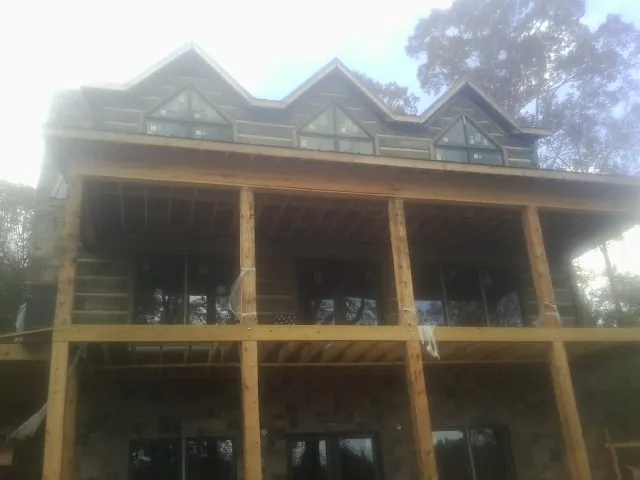 Dormers and porch framing on a large log home under construction — Roof Coating work by our crew in Morrisdale